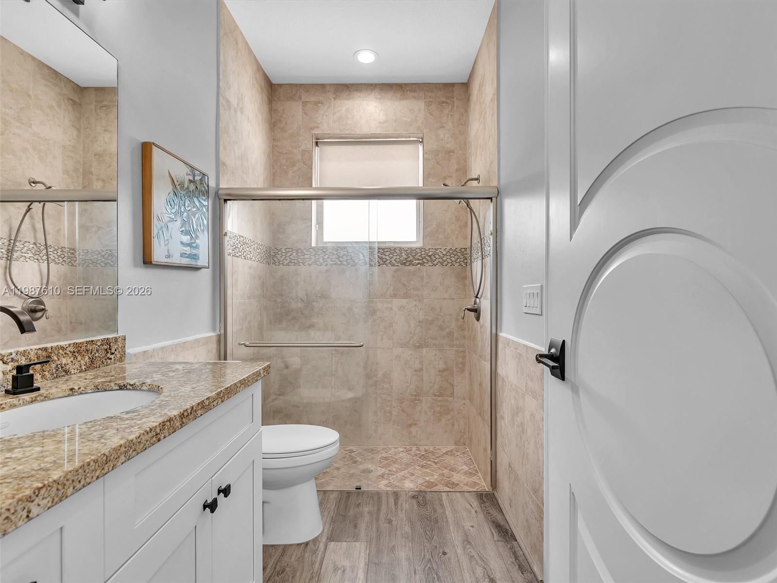 8878 Cobblestone Point Circle Boynton Beach, FL 33472 - Photo 30 of 89 a bathroom with a granite countertop sink toilet a mirror and shower