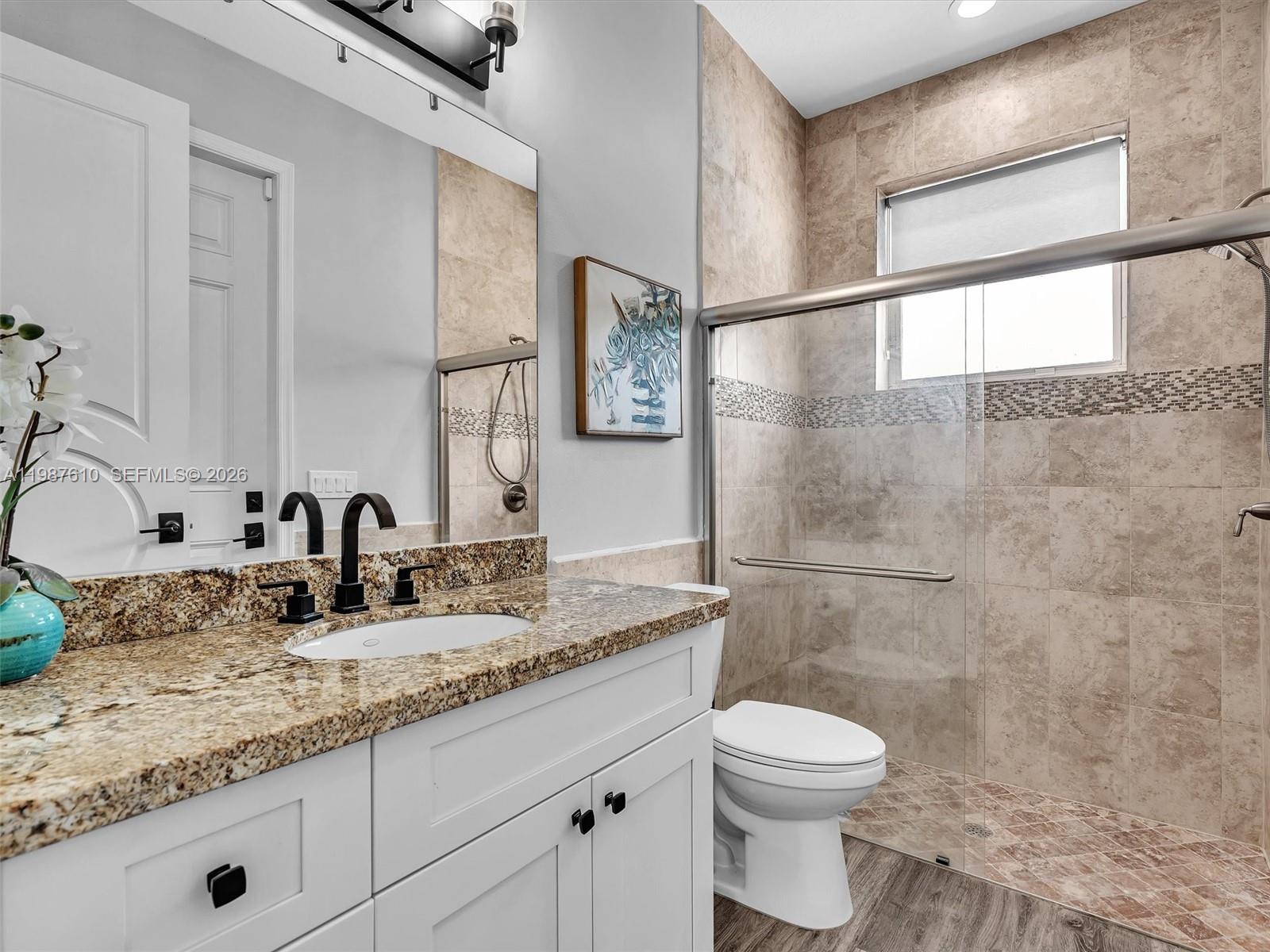 8878 Cobblestone Point Circle Boynton Beach, FL 33472 - Photo 31 of 89 a bathroom with a granite countertop sink toilet and shower