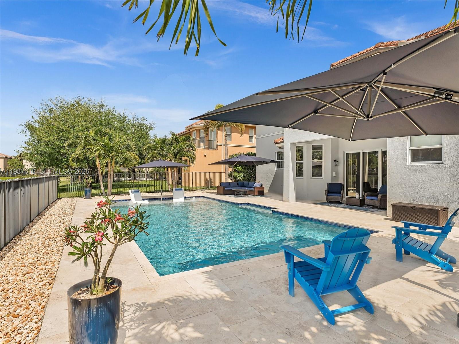 8878 Cobblestone Point Circle Boynton Beach, FL 33472 - Photo 4 of 89 a view of a patio with table and chairs under an umbrella
