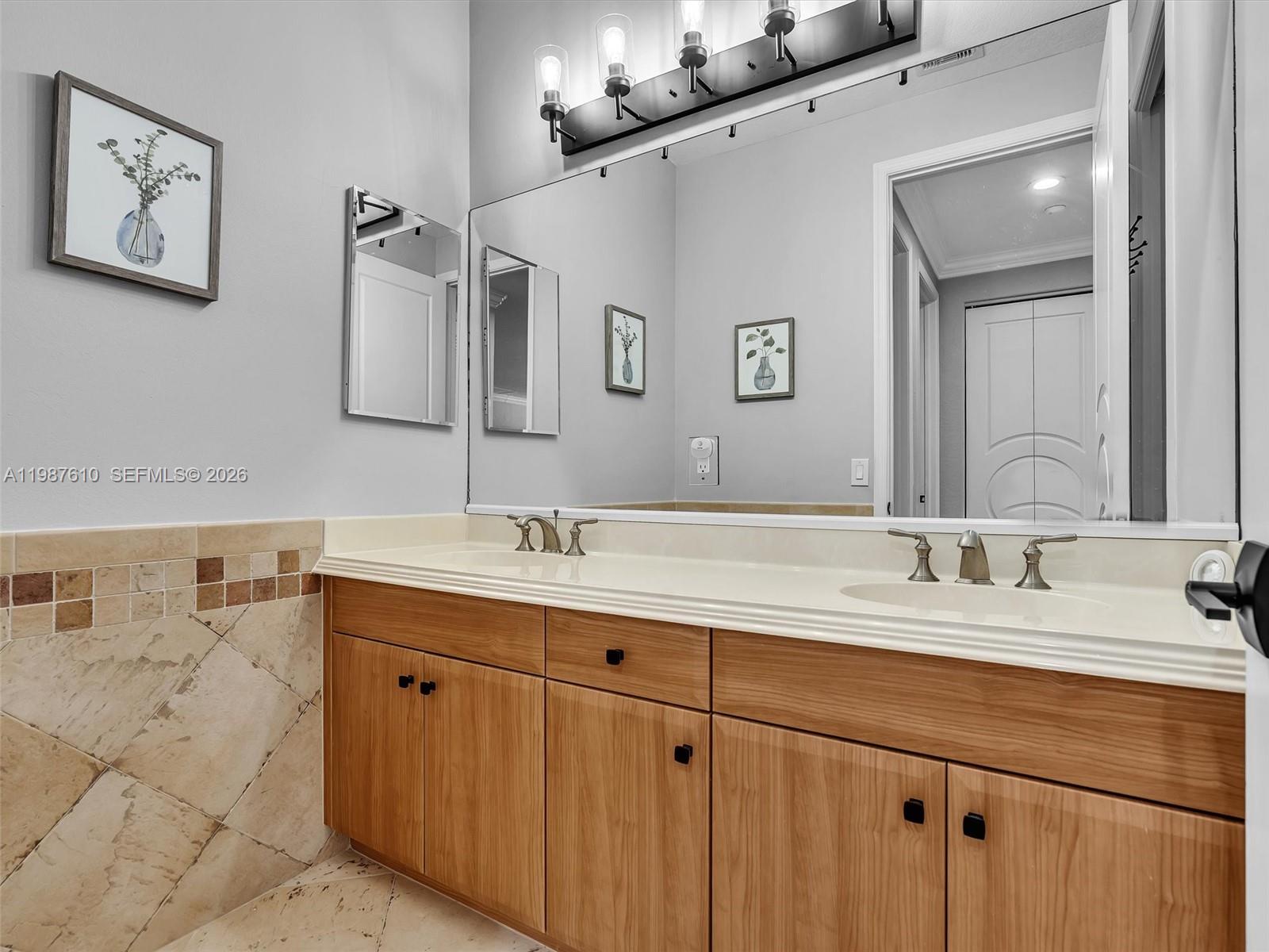 8878 Cobblestone Point Circle Boynton Beach, FL 33472 - Photo 60 of 89 a bathroom with a double vanity sink and a mirror