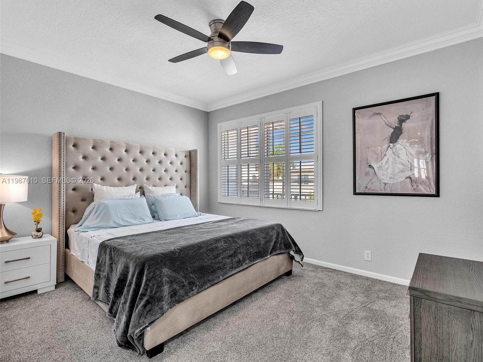 8878 Cobblestone Point Circle Boynton Beach, FL 33472 - Photo 67 of 89 a bedroom with a large bed and a chandelier