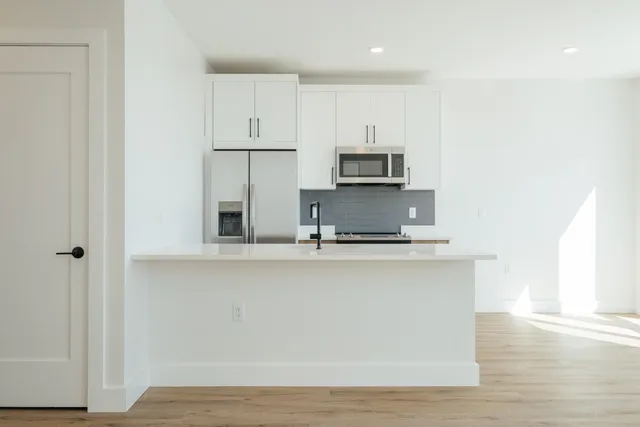 a kitchen with kitchen island a sink appliances and cabinets