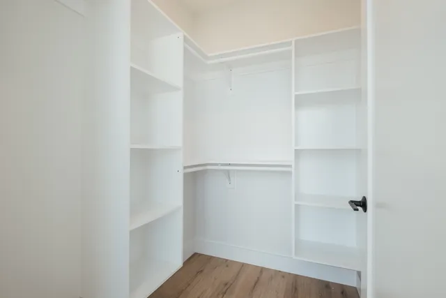 a view of walk in closet with empty racks