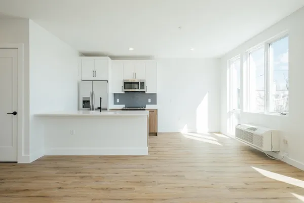 a view of kitchen with wooden floor and electronic appliances