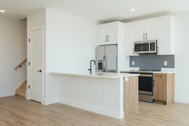 a kitchen with stainless steel appliances granite countertop a stove a sink and a refrigerator