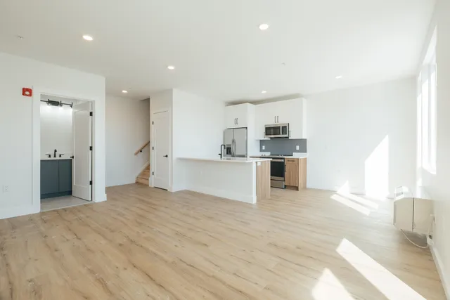 a view of a kitchen with a sink and dishwasher a refrigerator with wooden floor