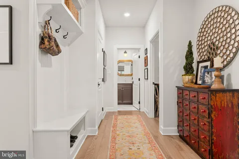 a view of a hallway with wooden floor and staircase