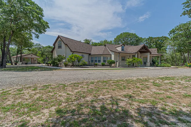 a front view of a house with a yard and trees