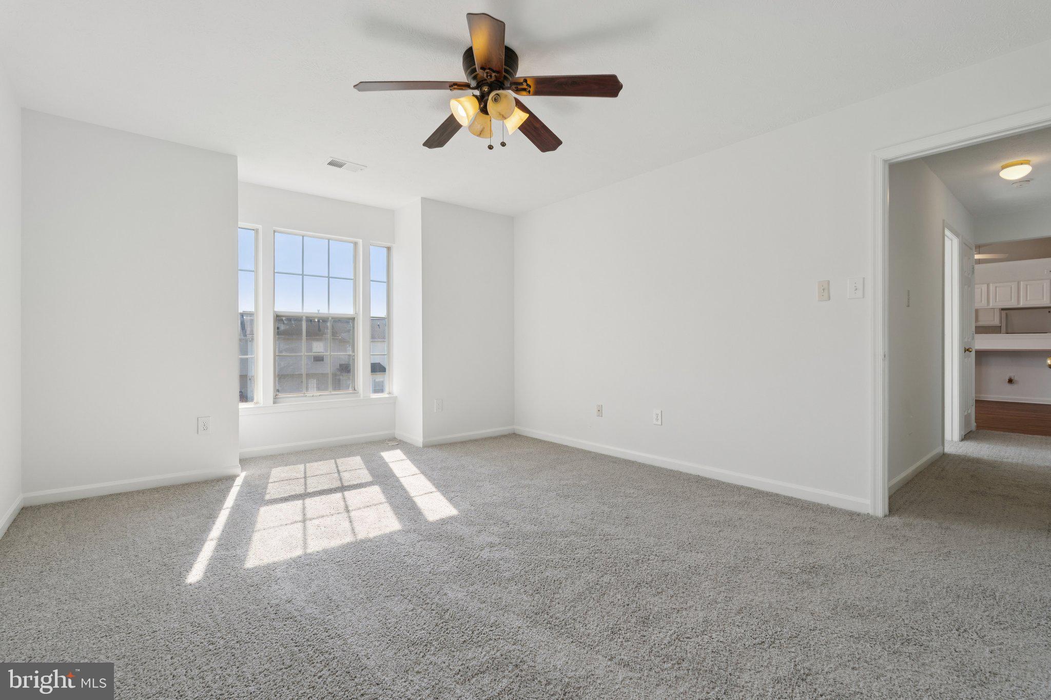 7655 Gladstone Road, Unit 5 Baltimore, MD 21244 - Photo 17 of 25 an empty room with windows and ceiling fan view