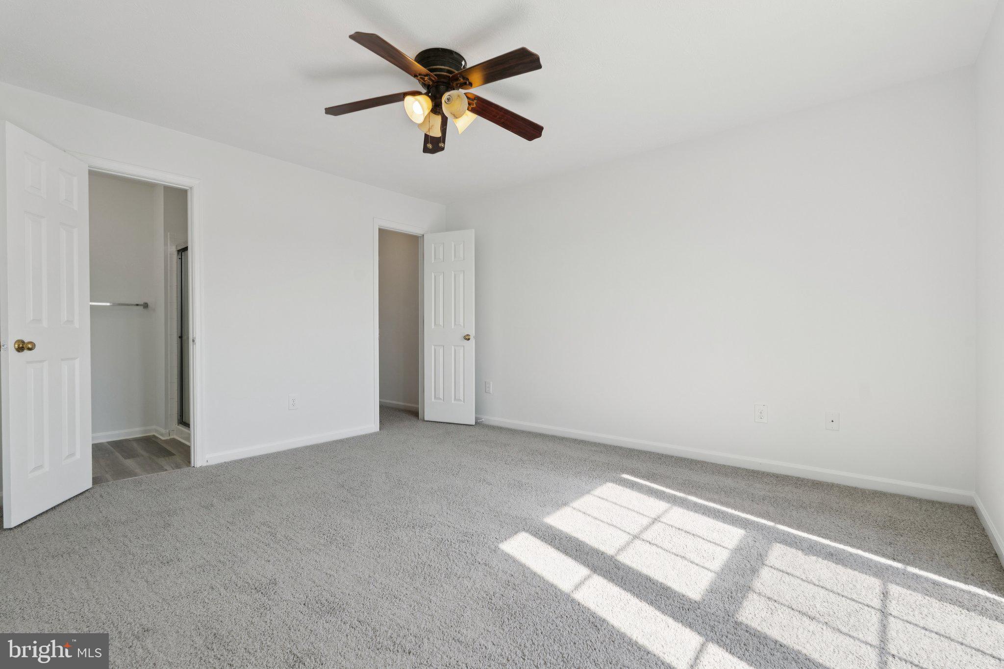 7655 Gladstone Road, Unit 5 Baltimore, MD 21244 - Photo 19 of 25 an empty room with chandelier fan and windows
