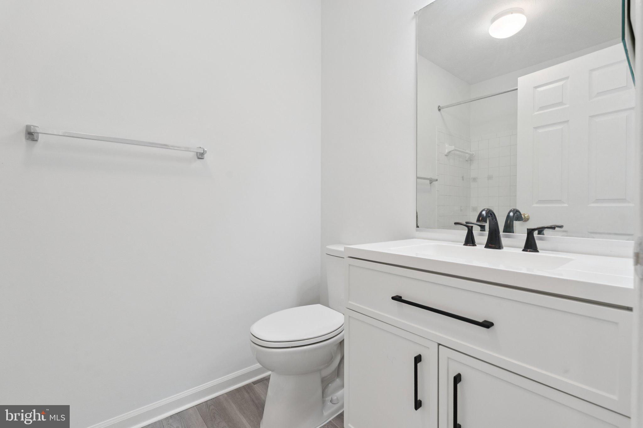 7655 Gladstone Road, Unit 5 Baltimore, MD 21244 - Photo 22 of 25 a bathroom with a sink a toilet and a mirror
