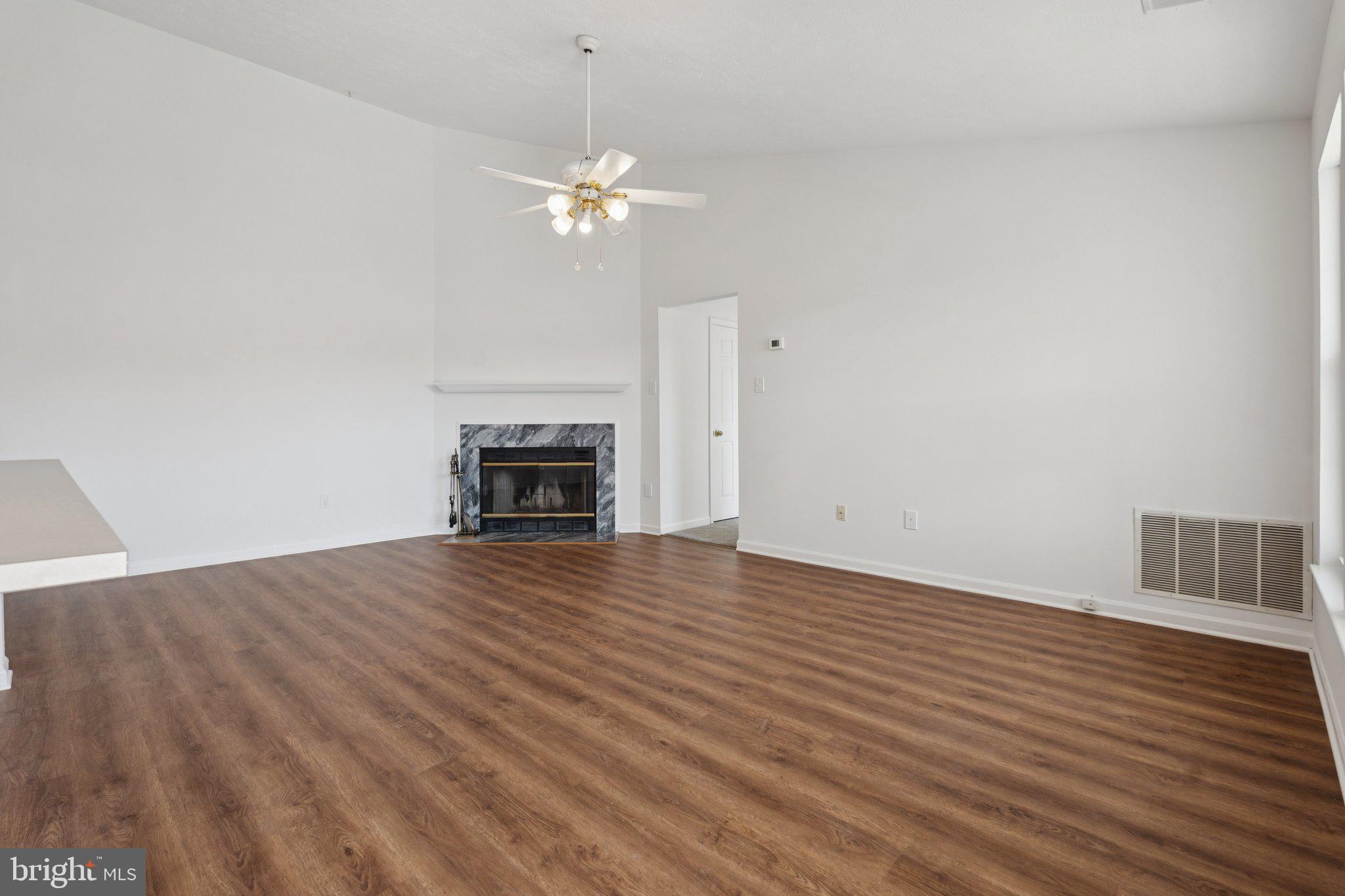 7655 Gladstone Road, Unit 5 Baltimore, MD 21244 - Photo 3 of 25 a view of empty room with wooden floor and fireplace