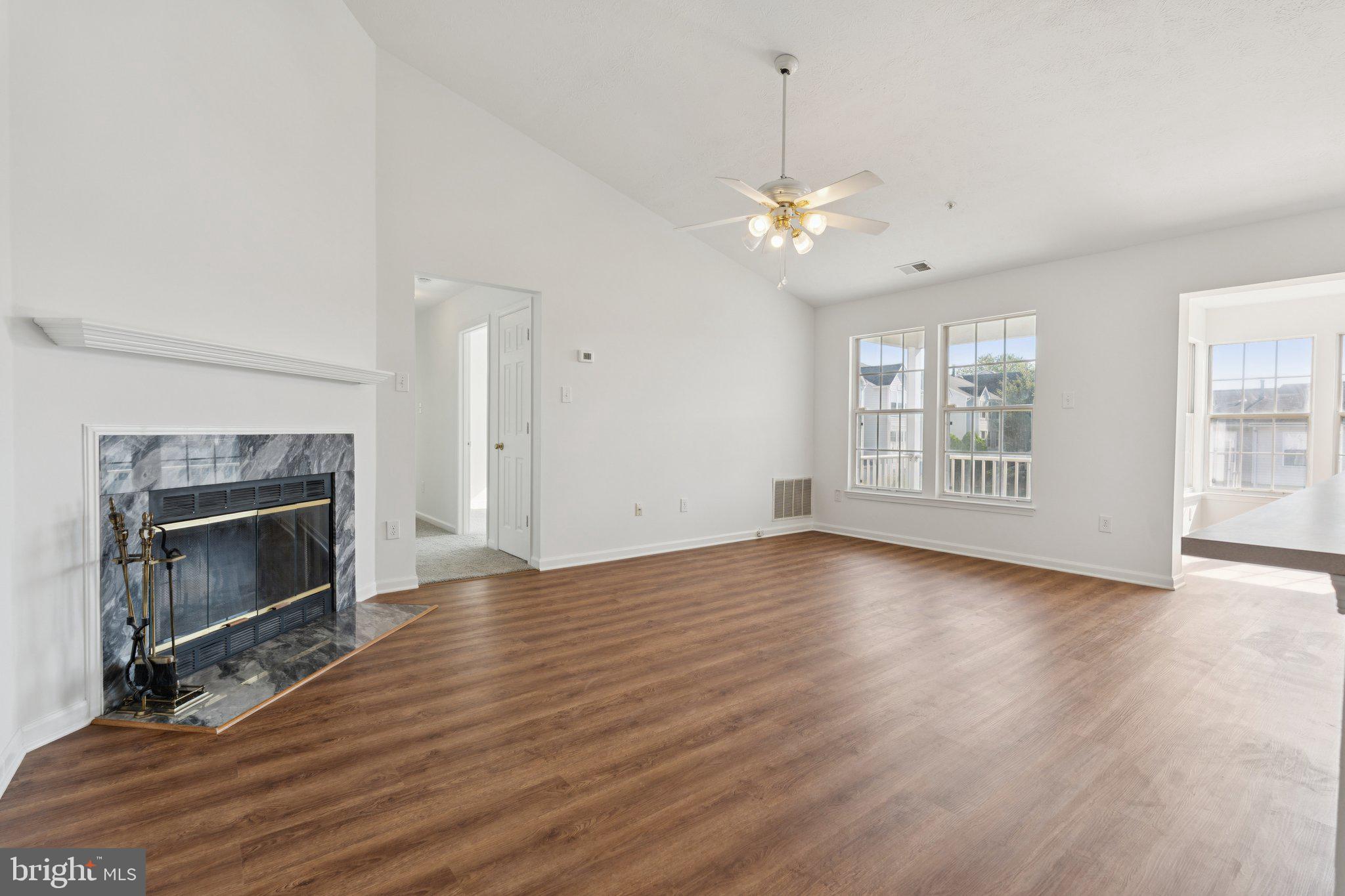 7655 Gladstone Road, Unit 5 Baltimore, MD 21244 - Photo 5 of 25 an empty room with wooden floor fireplace and windows