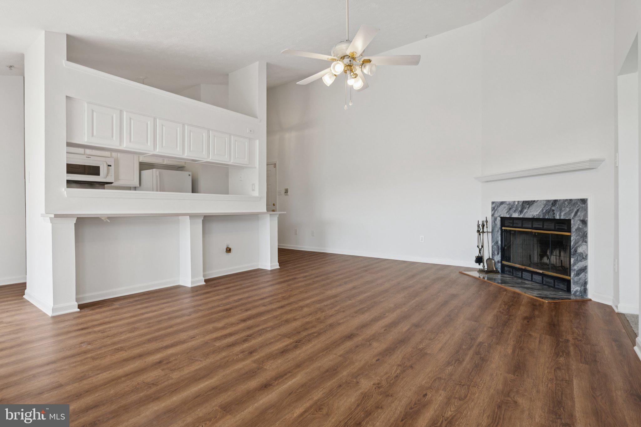 7655 Gladstone Road, Unit 5 Baltimore, MD 21244 - Photo 6 of 25 a view of empty room with kitchen and fireplace
