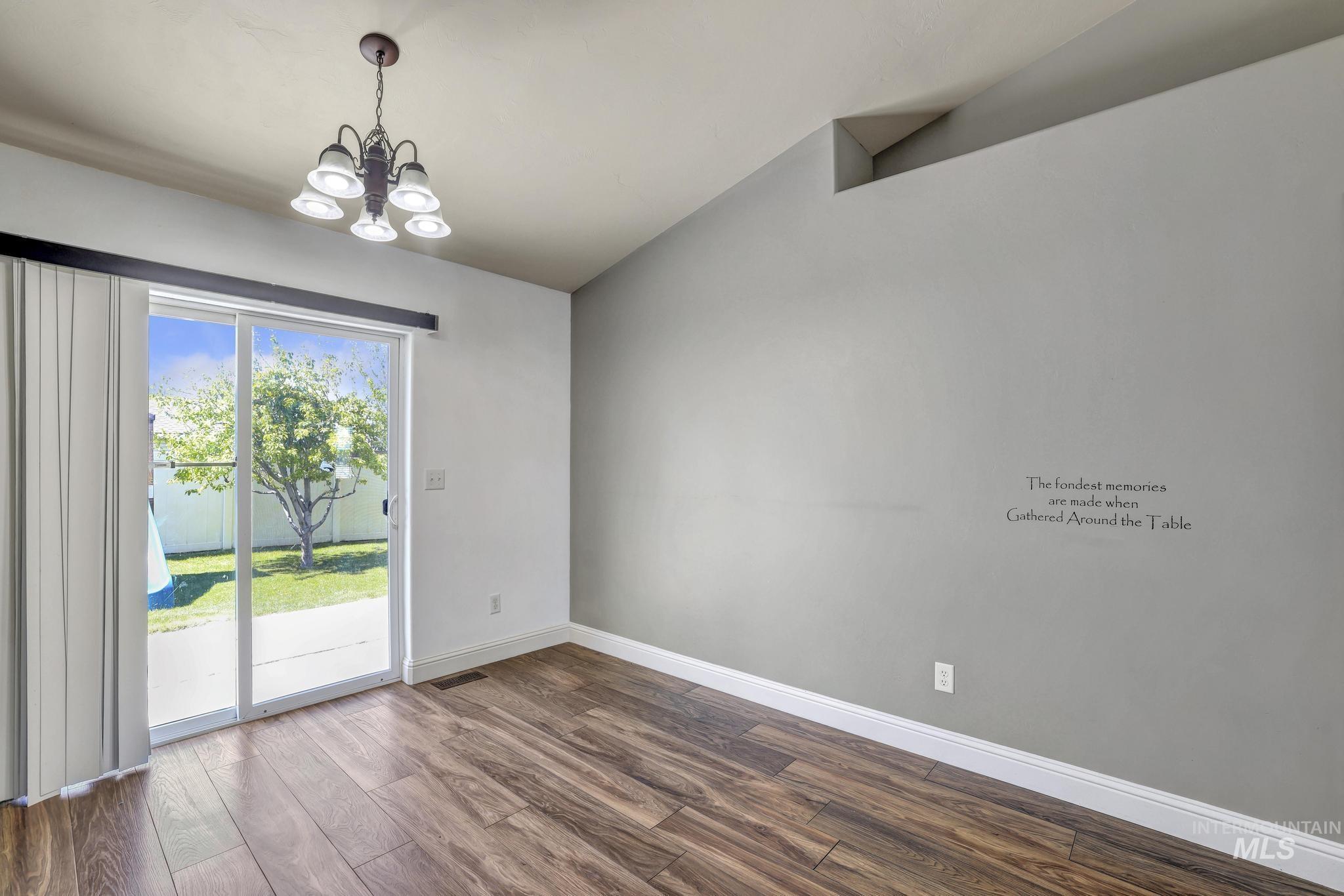 446 Noble Street Twin Falls, ID 83301 - Photo 7 of 42 Dining area with wood-finish flooring, a contemporary chandelier, and direct access to the outdoor patio