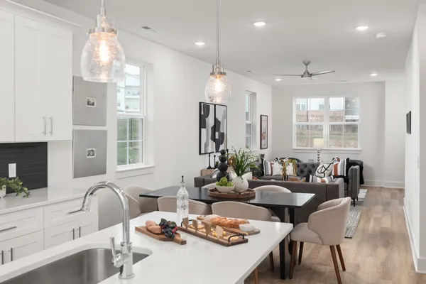 a living room with furniture kitchen and a large window