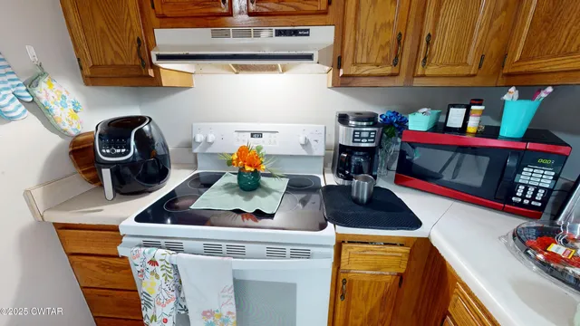 a kitchen with stainless steel appliances granite countertop a stove a microwave and cabinets