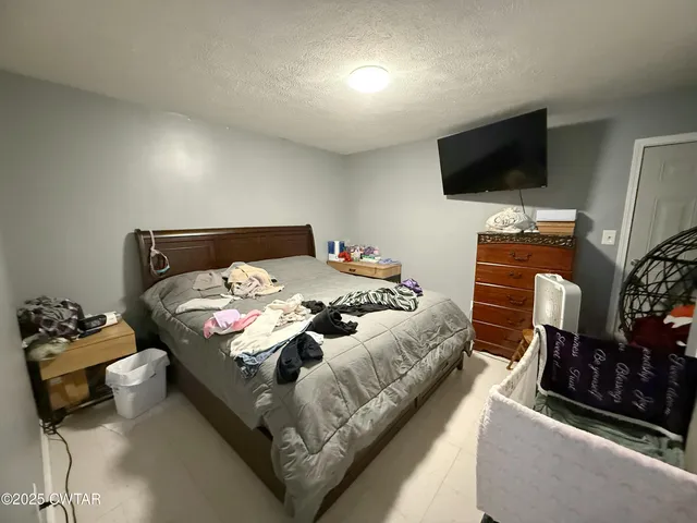a bedroom with a bed and flat screen tv