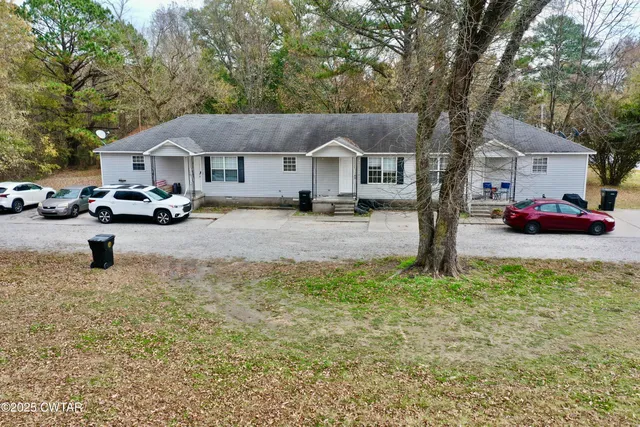 a front view of a house with cars parked