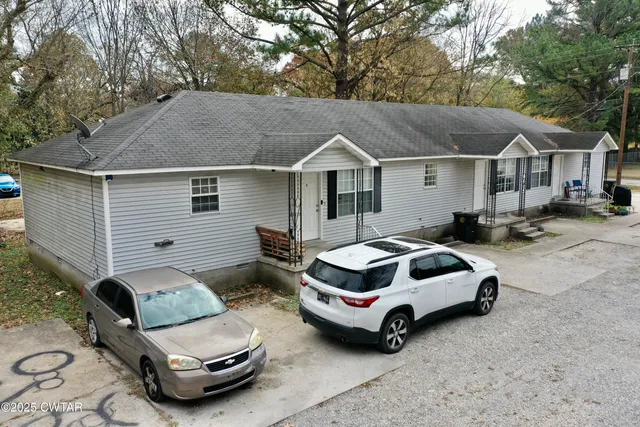 a car parked in front of white house