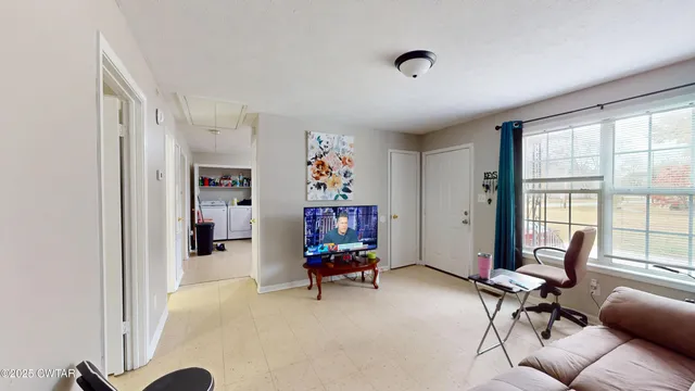 a view of a livingroom with workspace and a window