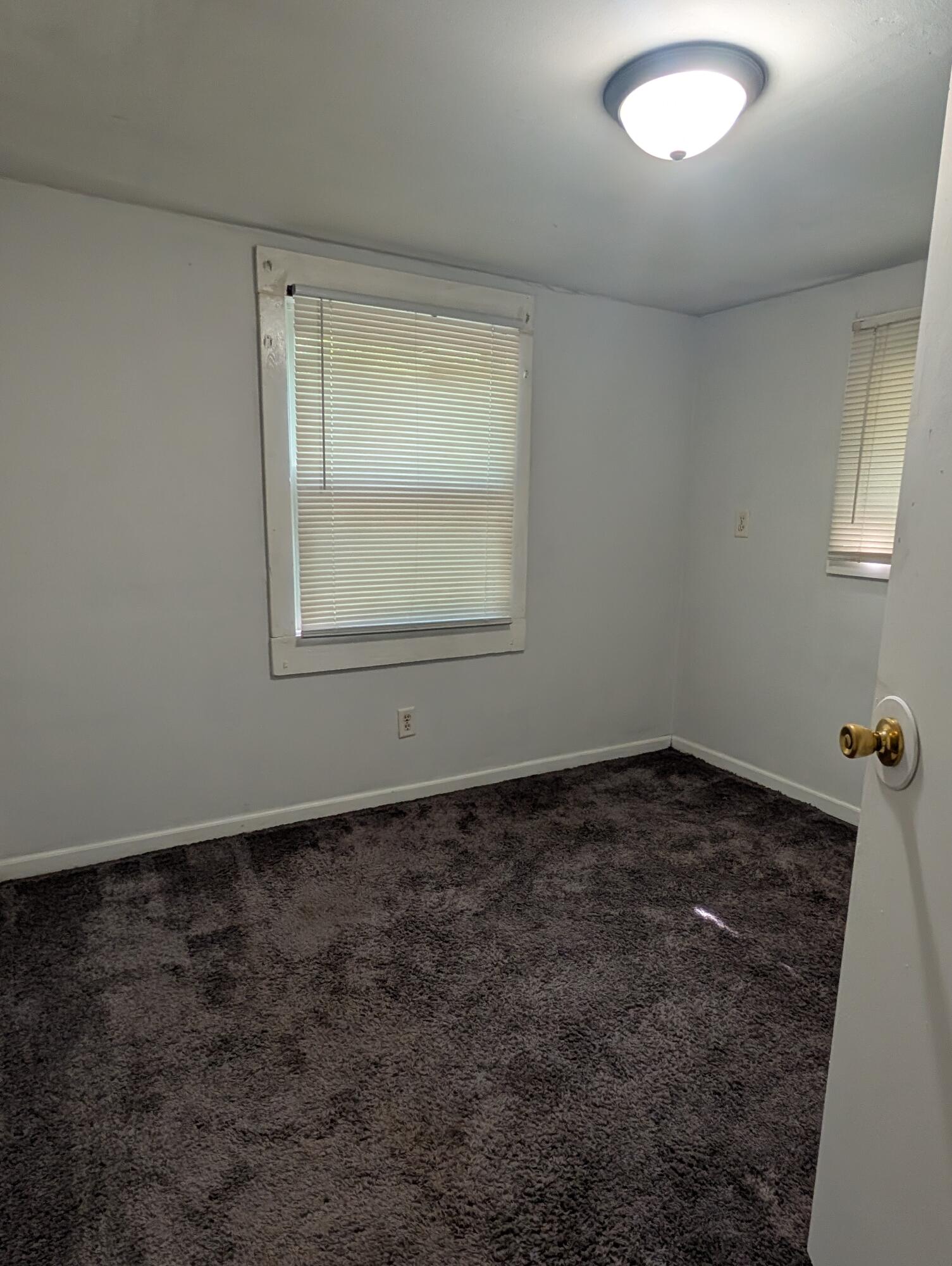 1910 South Calhoun Street Griffith, IN 46319 - Photo 4 of 19 an empty room with a chair and a window