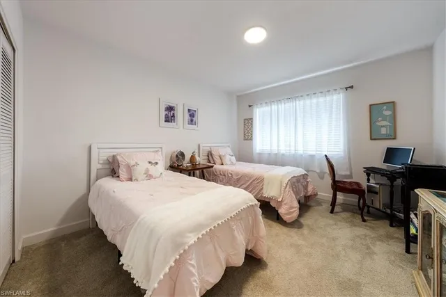 a bedroom with two beds and a desk