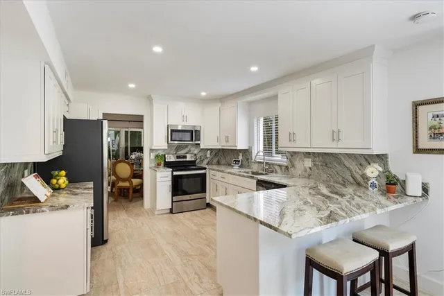 a kitchen that has a lot of cabinets a sink and appliances in it