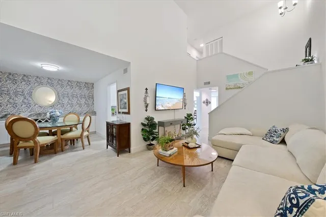 a living room with furniture a table and kitchen chandelier