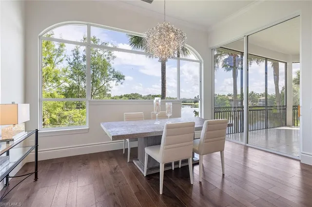a view of a dining room with furniture a chandelier and wooden floor