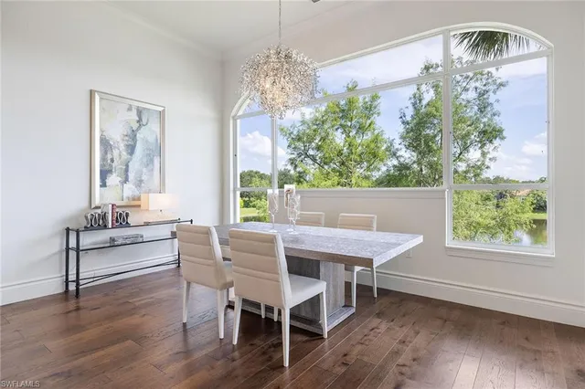 a view of a dining room with furniture a chandelier and wooden floor
