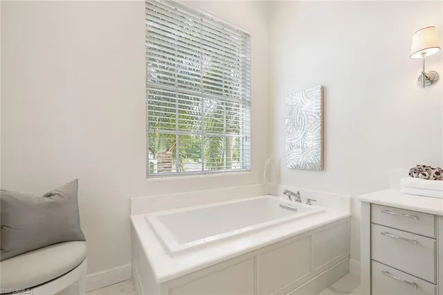 a bathroom with a tub sink and mirror