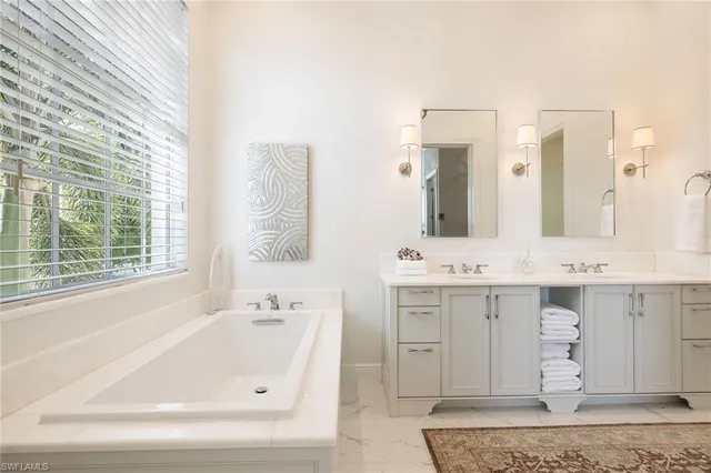 a bathroom with a tub sink and mirror