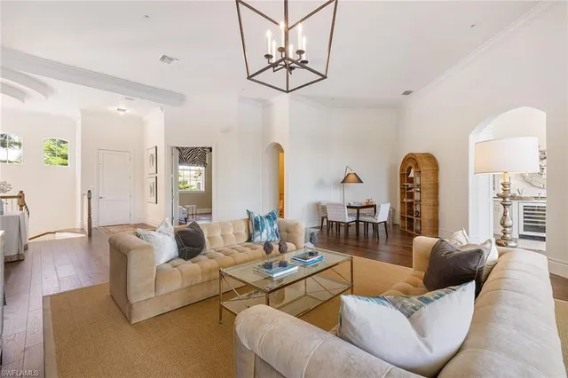 a living room with furniture and a chandelier
