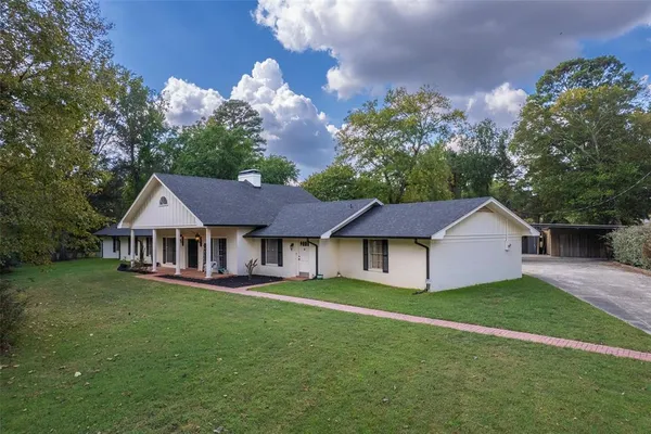 a house that has a lot of big trees plants