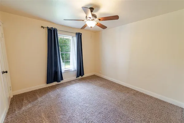 a view of a livingroom with a ceiling fan and window