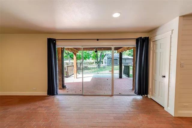 an empty room with wooden floor and sliding glass door