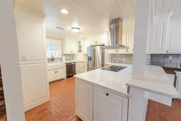 a kitchen with a sink a stove cabinets and a refrigerator