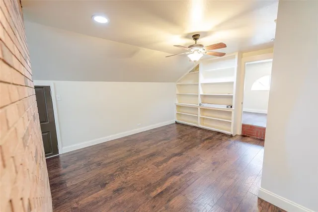 a view of a room with wooden floor and a ceiling fan