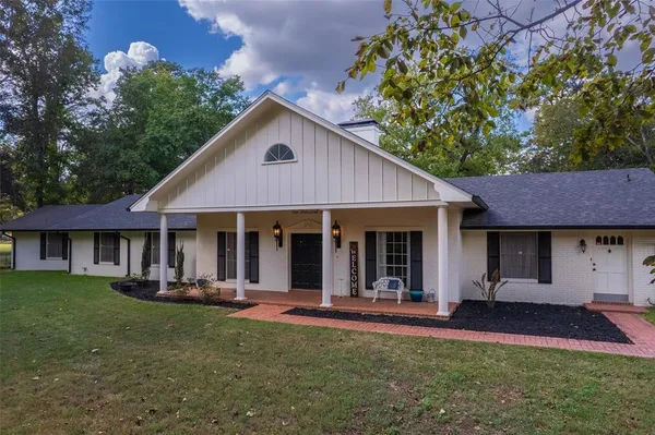 a front view of a house with a yard garden and outdoor seating