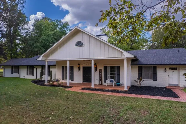 a front view of a house with a yard garden and outdoor seating