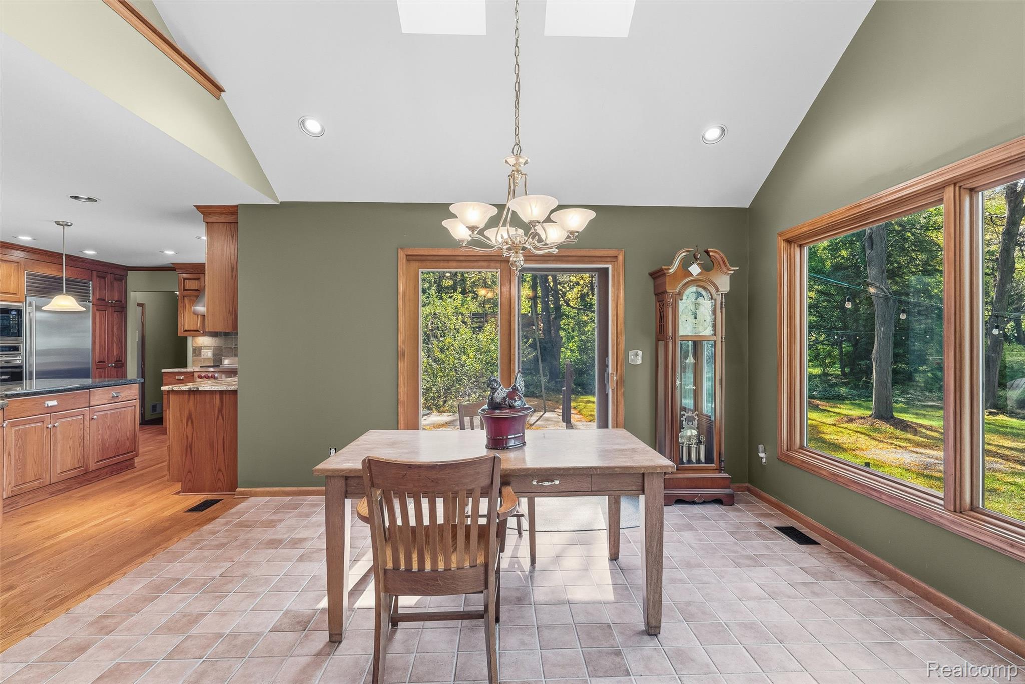 8135 Ranch Estates Road Clarkston, MI 48348 - Photo 17 of 53 Vaulted ceiling with skylight, tile flooring, large picture windows, and wood-paneled sliding glass door
