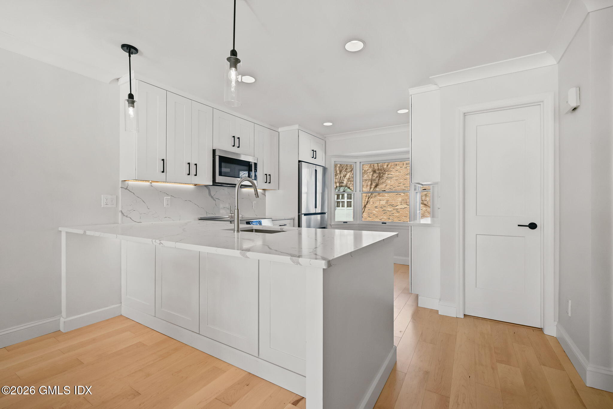 115 River Road, Unit 7 Cos Cob, CT 06807 - Photo 6 of 17 a kitchen with kitchen island white cabinets and refrigerator