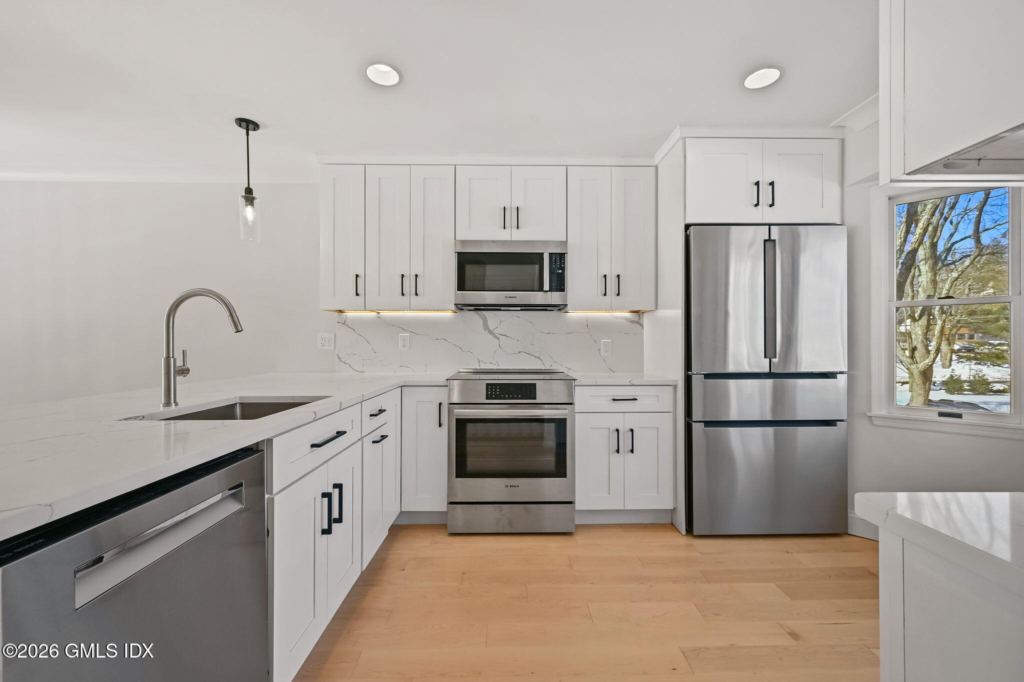 115 River Road, Unit 7 Cos Cob, CT 06807 - Photo 7 of 17 a kitchen with stainless steel appliances granite countertop a refrigerator stove and sink