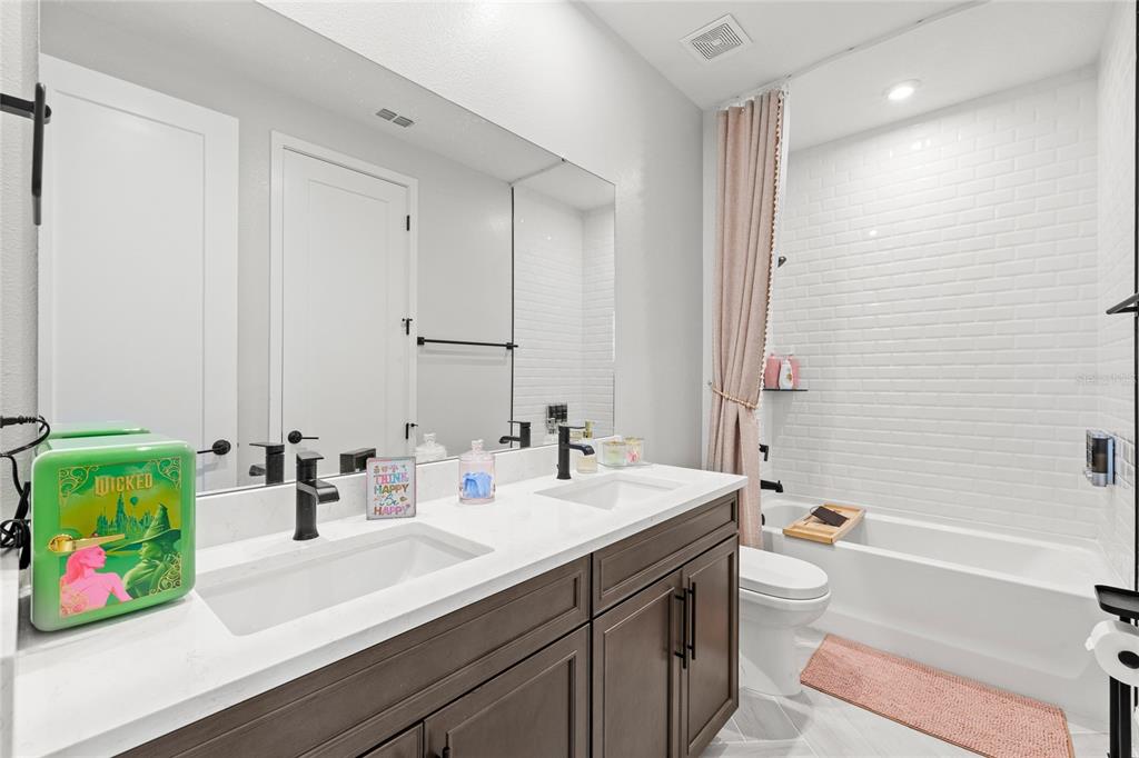 7445 Estuary Lk Loop Kissimmee, FL 34747 - Photo 26 of 54 a bathroom with a double vanity sink mirror and toilet