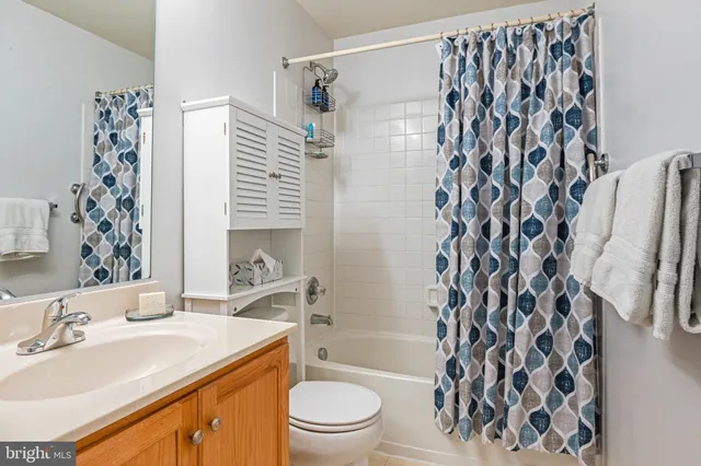 a bathroom with a sink toilet a shower curtain and a large mirror