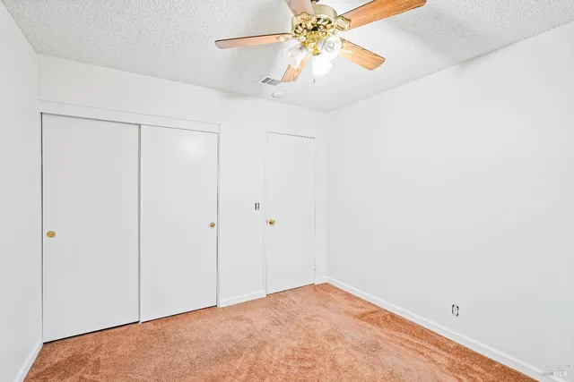 an empty room with a chandelier fan