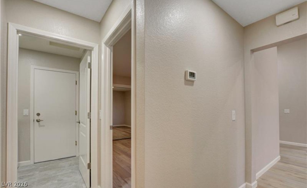 2716 Showcase Drive Las Vegas, NV 89134 - Photo 11 of 45 A well-lit interior hallway offers clean lines and warm, inviting finishes, with durable flooring leading to various rooms.