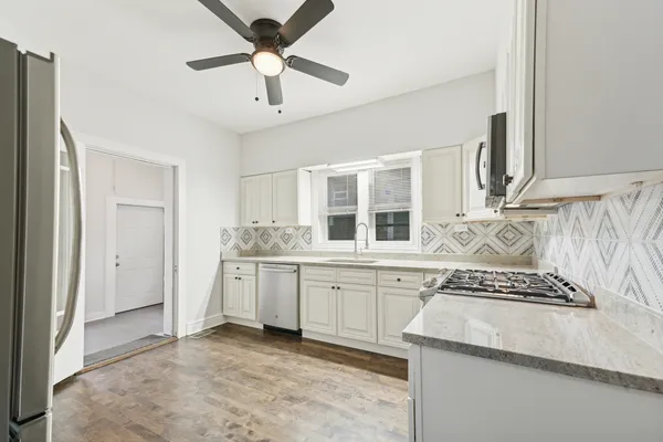 a kitchen with granite countertop cabinets a sink a window and stainless steel appliances