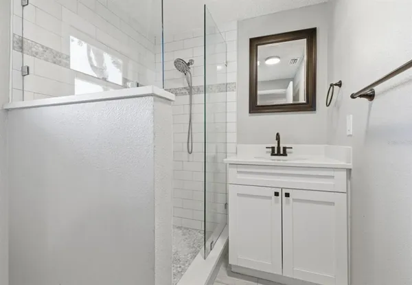 a bathroom with a shower sink and mirror